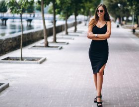 femme en robe noire lunette de soleil en ville